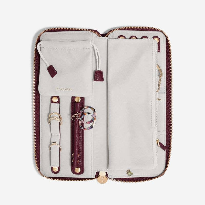 Large burgundy Stackers travel jewellery roll, displayed open with various compartments on a white background