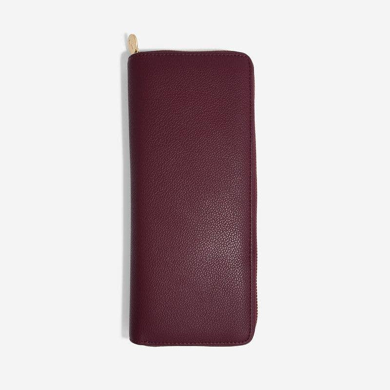 Large burgundy Stackers brand travel jewellery roll on a white background