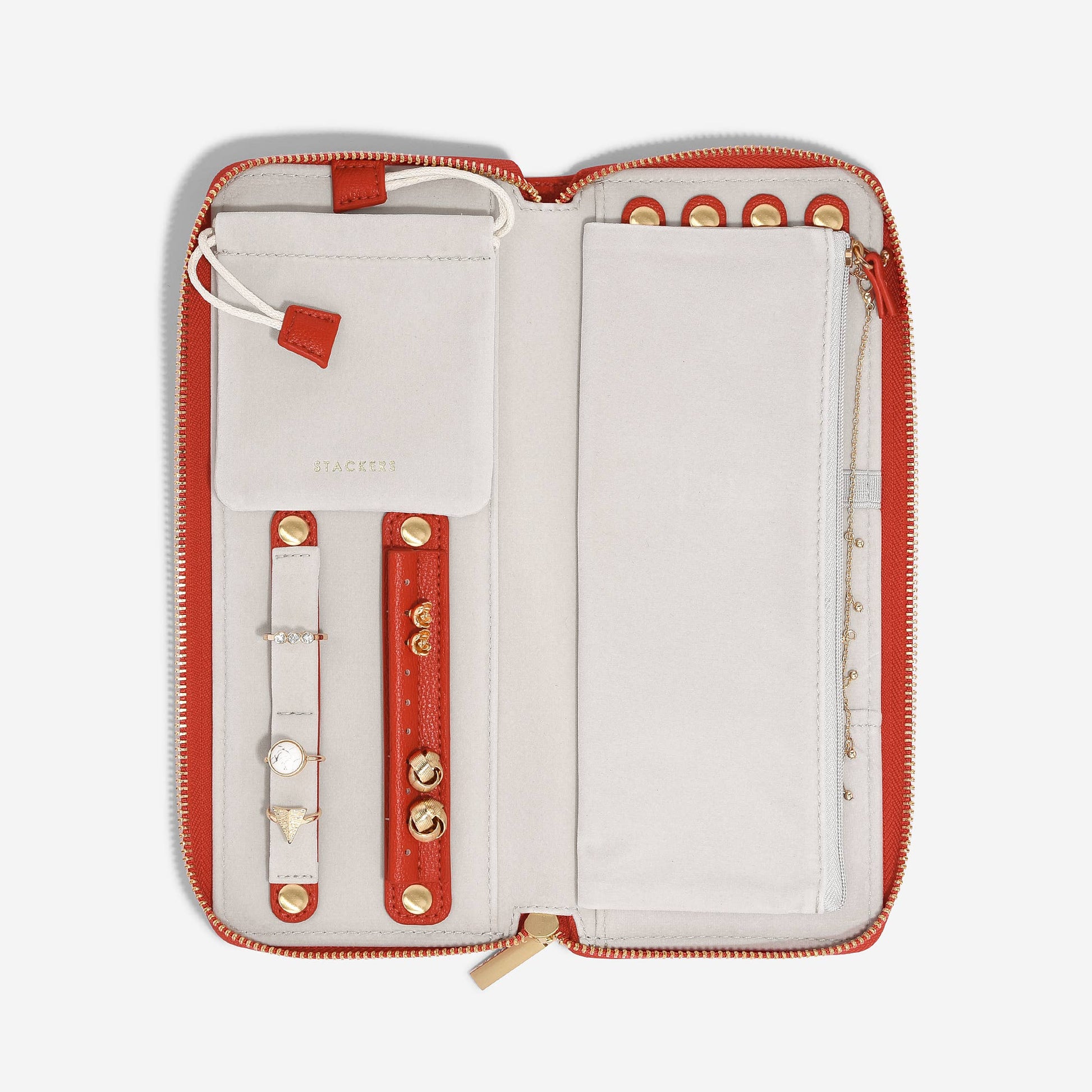 Open red and white wallet with jewelry on a white background