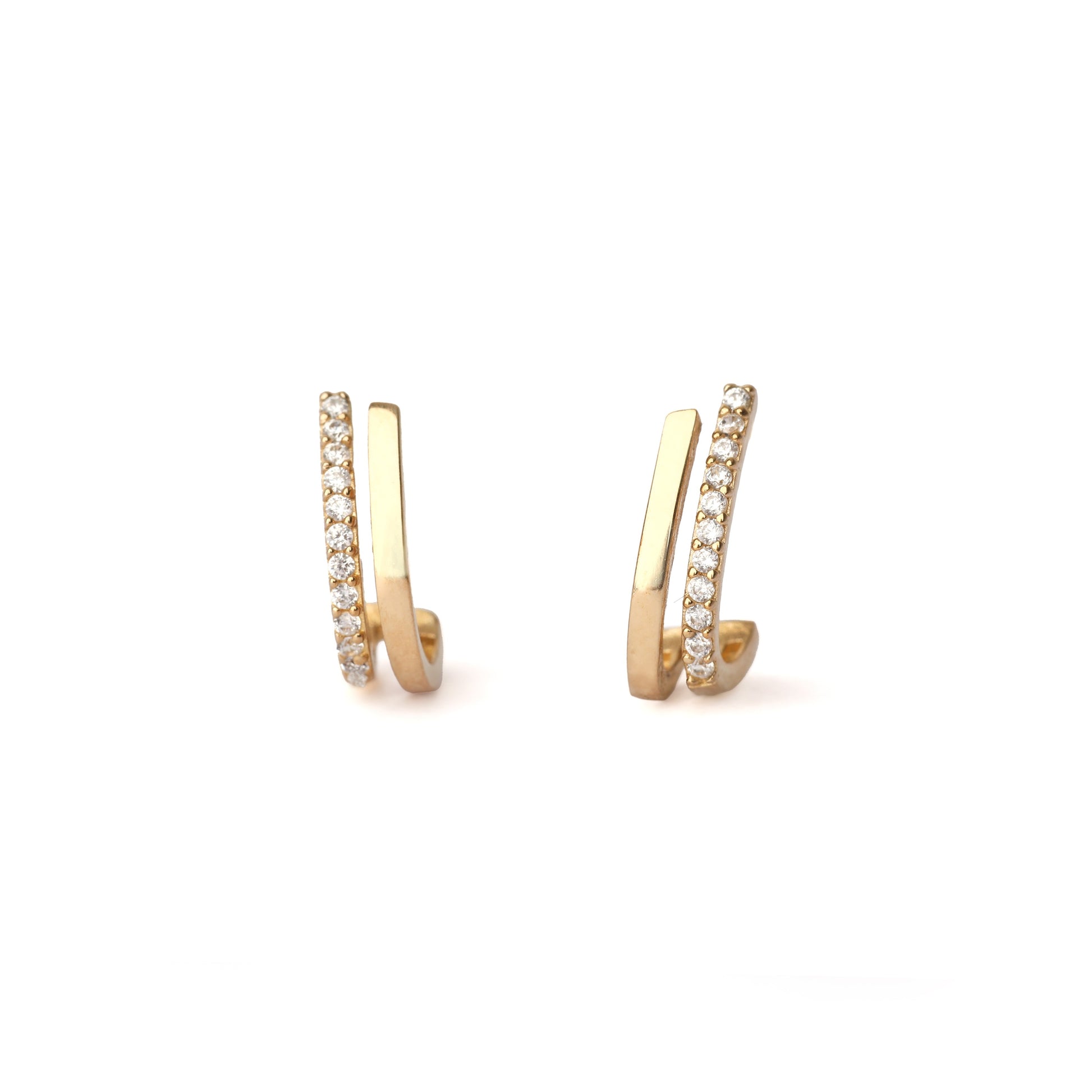 A pair of solid yellow gold half hoop earrings set with cubic zirconia along one edge. The earrings are facing forward and both are on a white background for the shopper to view.