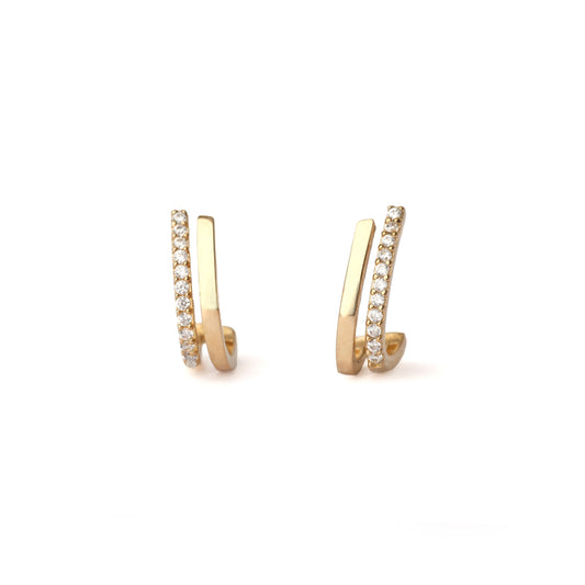 A pair of solid yellow gold half hoop earrings set with cubic zirconia along one edge. The earrings are facing forward and both are on a white background for the shopper to view.