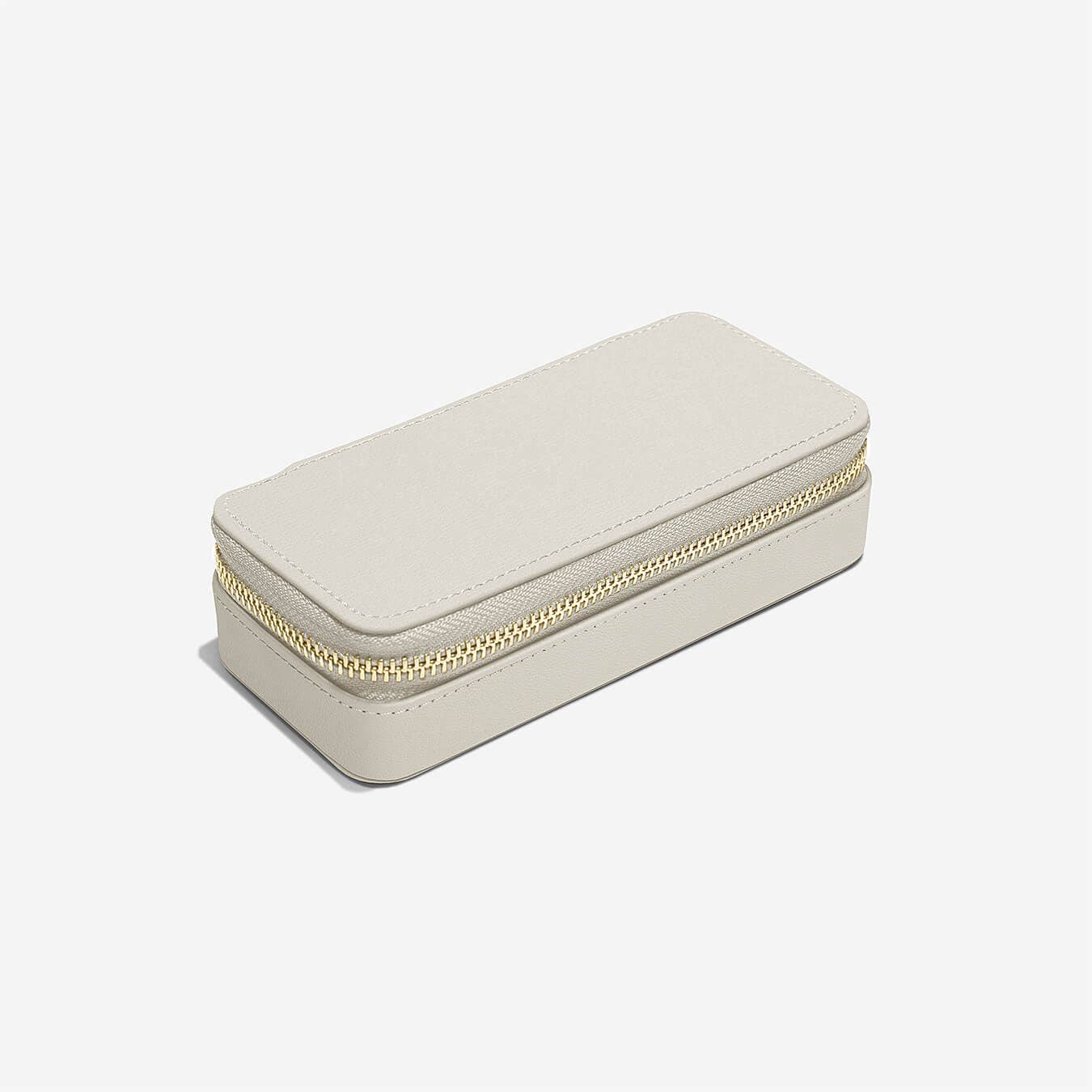 Small beige jewelry box with a gold zipper on a white background