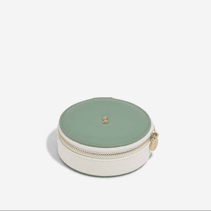 Round jewellery case with green top and white base on a white background