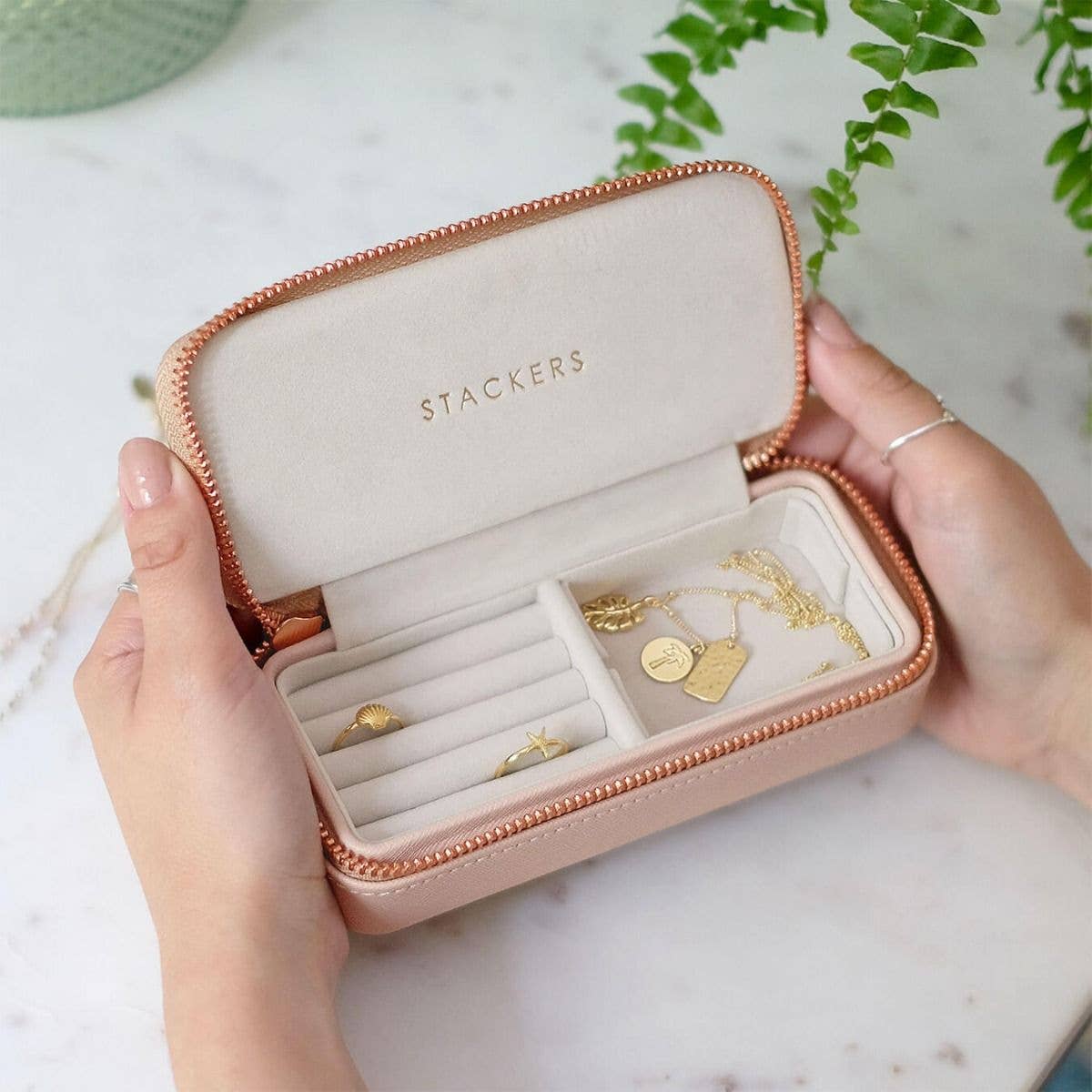 Medium blush pink Stackers jewellery case box held by hands on a light background