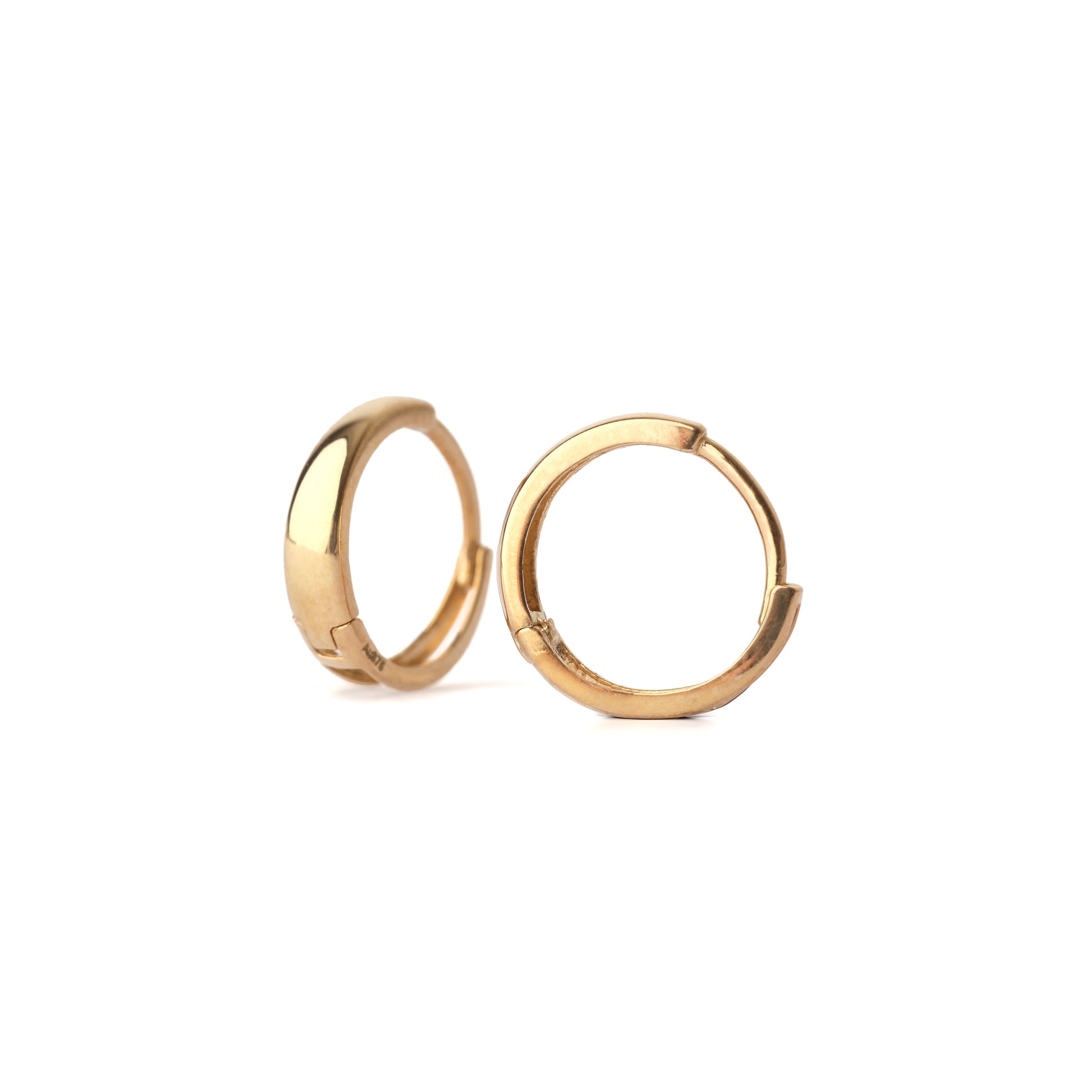 A pair of solid yellow gold huggie hoop earrings on a white background. One is facing forward the other at an angle.