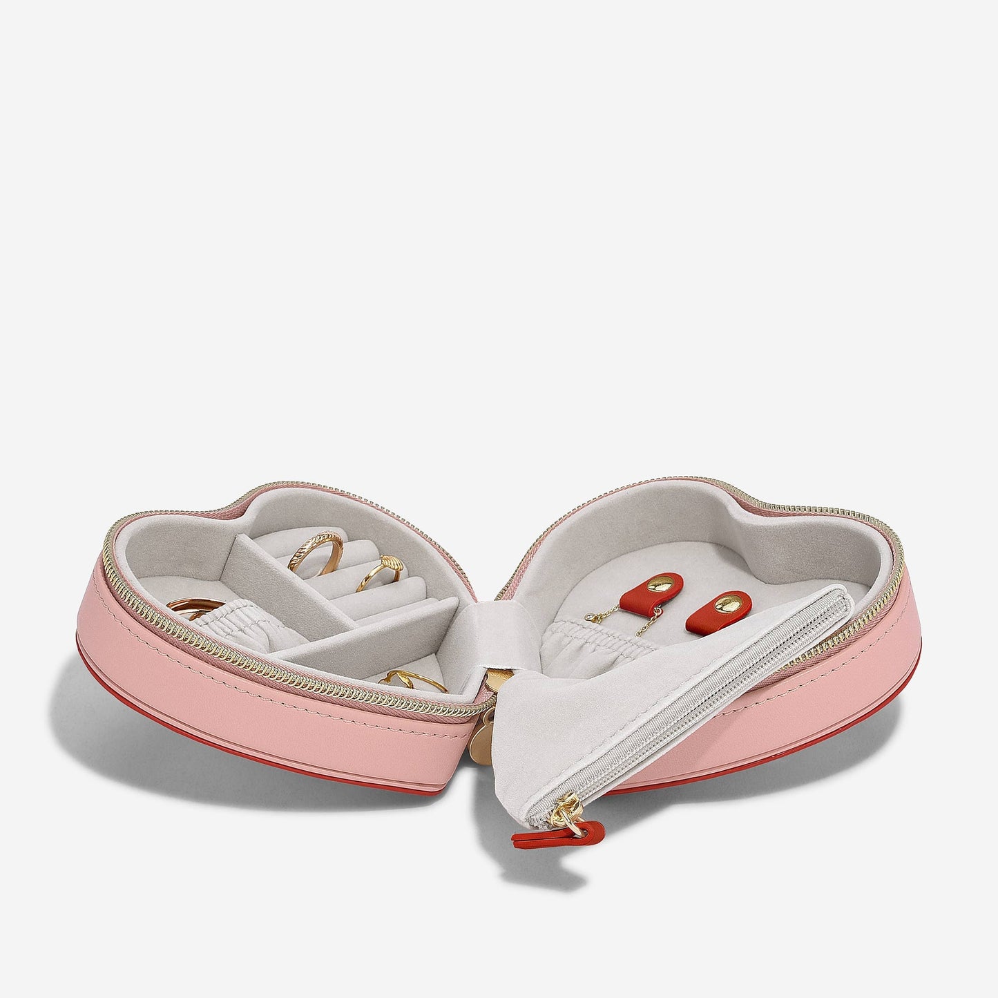Heart-shaped pink and red Stackers travel jewellery case on a white background.