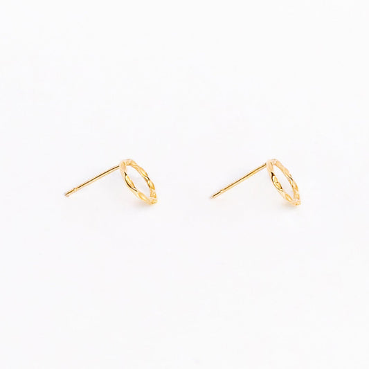 A pair of solid yellow gold circle stud earrings. Both earrings are facing sideways and are set on a white background for the shopper to view.