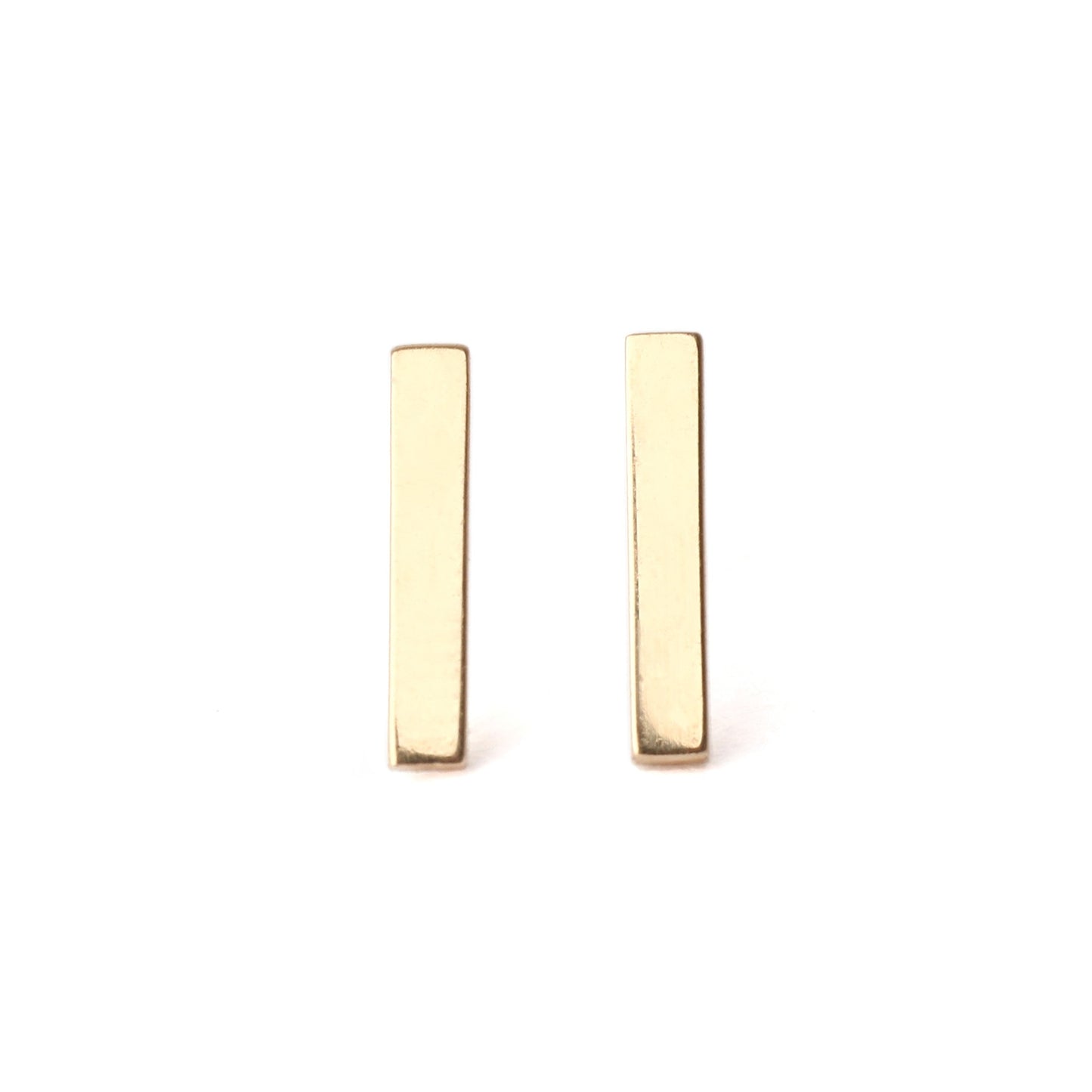 A pair of solid yellow gold bar stud earrings set on a white background for the shopper to view, both facing forwards.