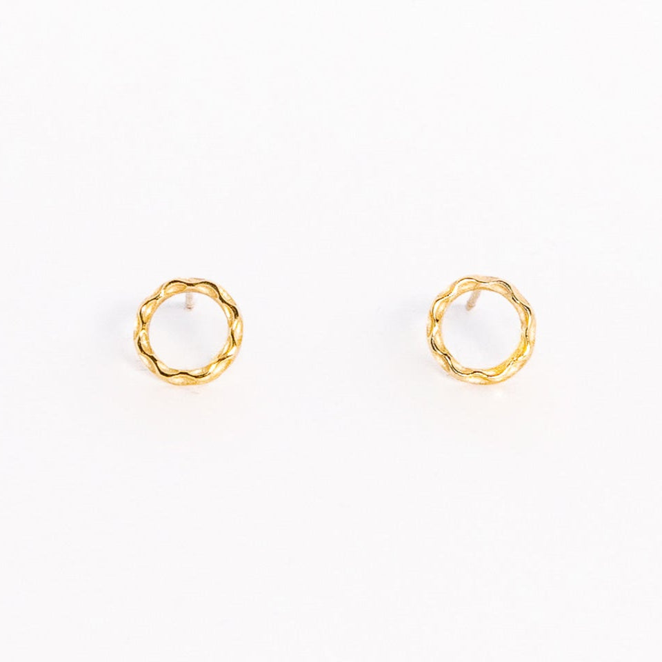 A pair of solid yellow gold circle stud earrings. Both earrings are facing forward and are set on a white background for the shopper to view.