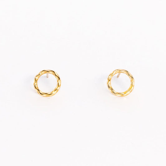 A pair of solid yellow gold circle stud earrings. Both earrings are facing forward and are set on a white background for the shopper to view.