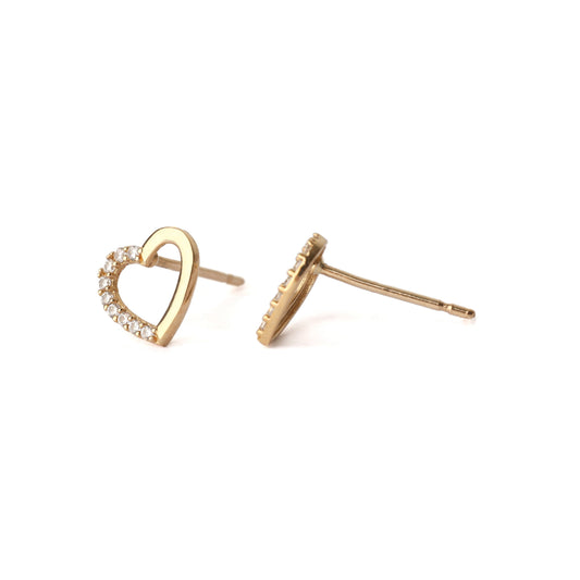 A pair of solid yellow gold heart shape earrings with an open centre. each earring has small cubic zirconia gemstones set into one side of the heart outline. One earring faces front and the other is side n and both are displayed on a white background for the shopper to see.