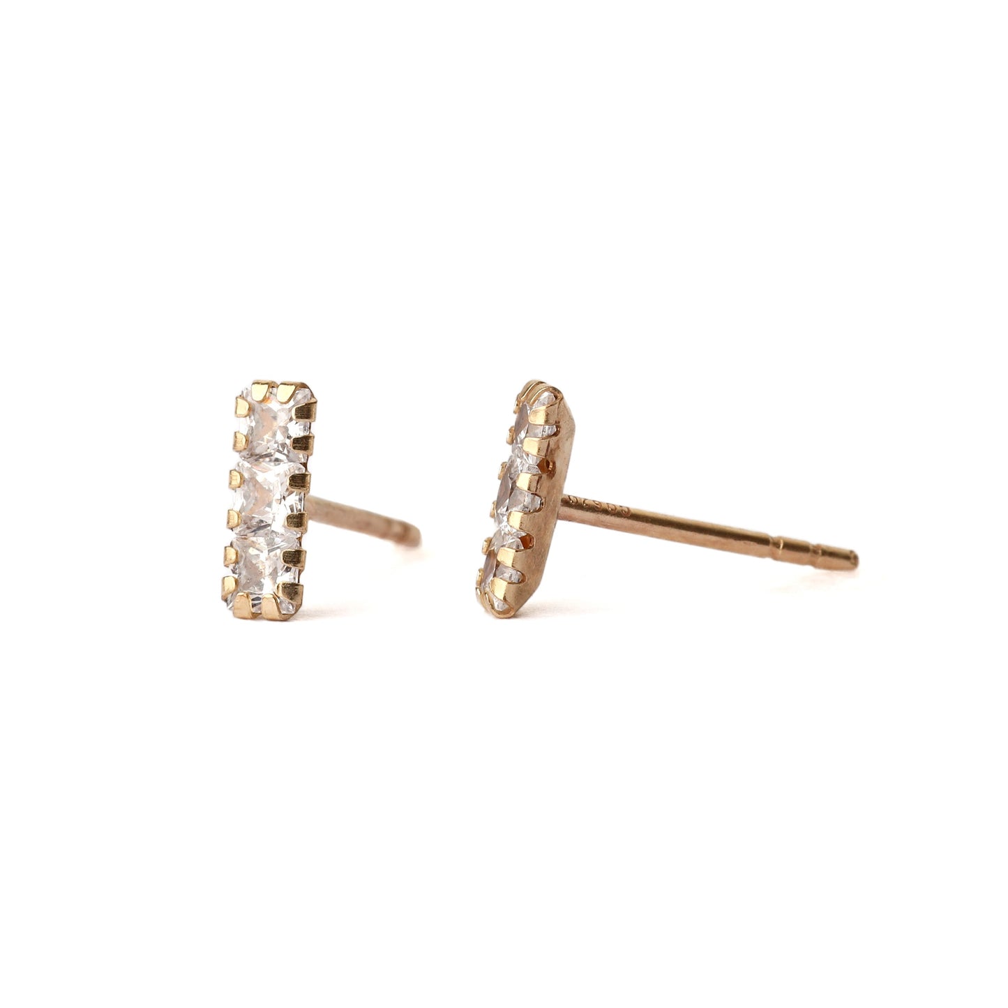 A pair of solid yellow gold studs with three small cubic zirconia gemstones in each, set in a rectangle shape. One stud faces forward the other is side on and both are displayed for the shopper on a white background.