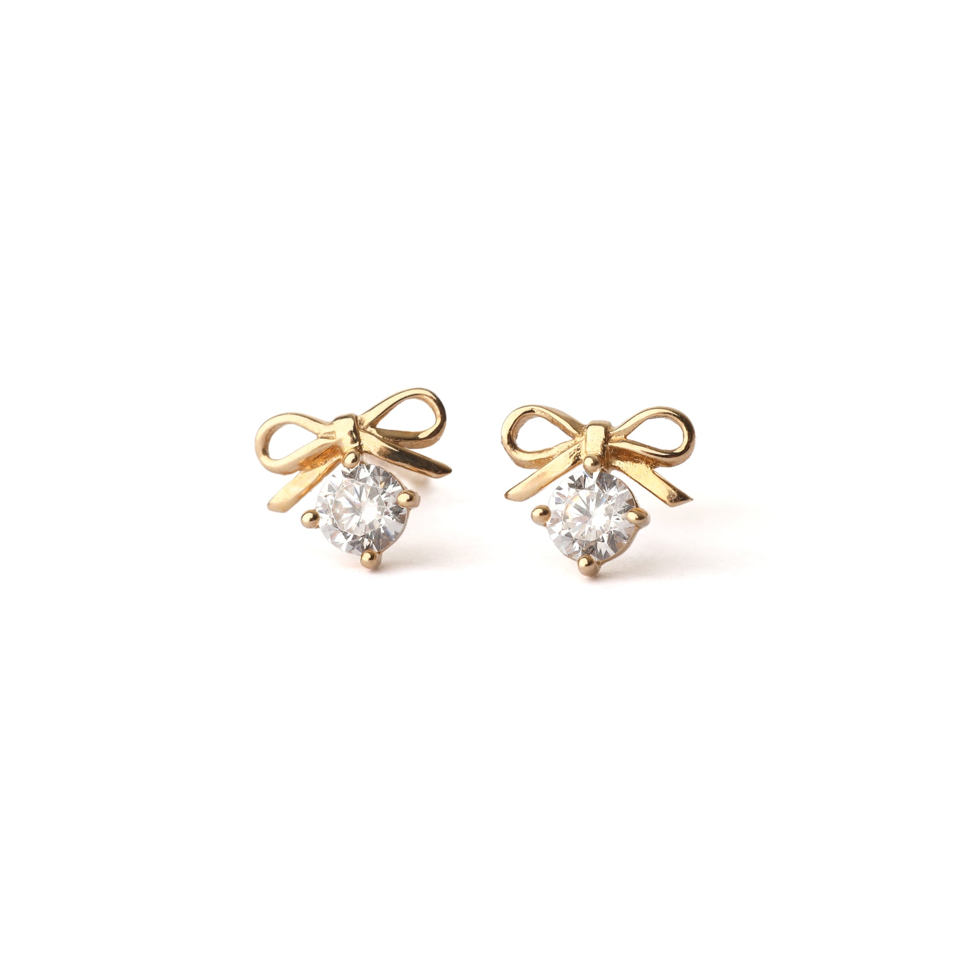 A pair of solid yellow gold bow earrings with a moissanite gemstone under the bow. Both earrings face forwards and are set on a white background for the shopper to view.