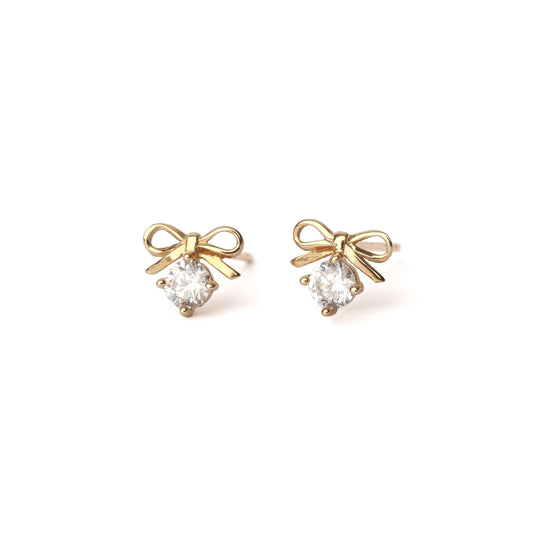 A pair of solid yellow gold bow earrings with a moissanite gemstone under the bow. Both earrings face forwards and are set on a white background for the shopper to view.