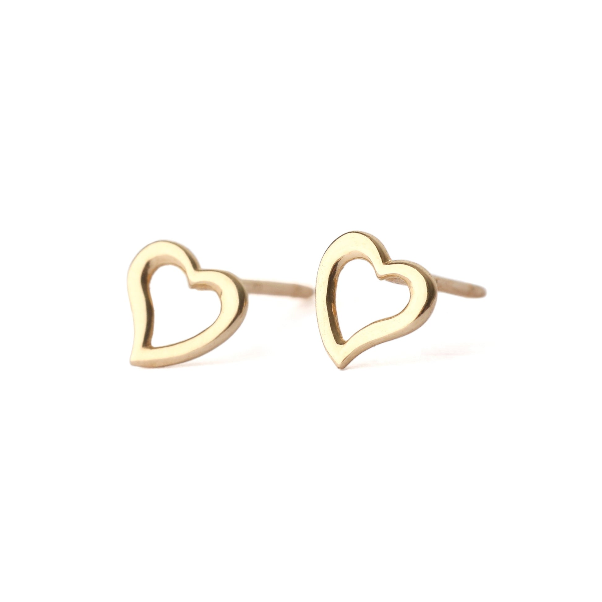 A pair of solid yellow gold heart shape earrings with an open centre, displayed on a white background, one facing forward and one side on for the shopper to see.