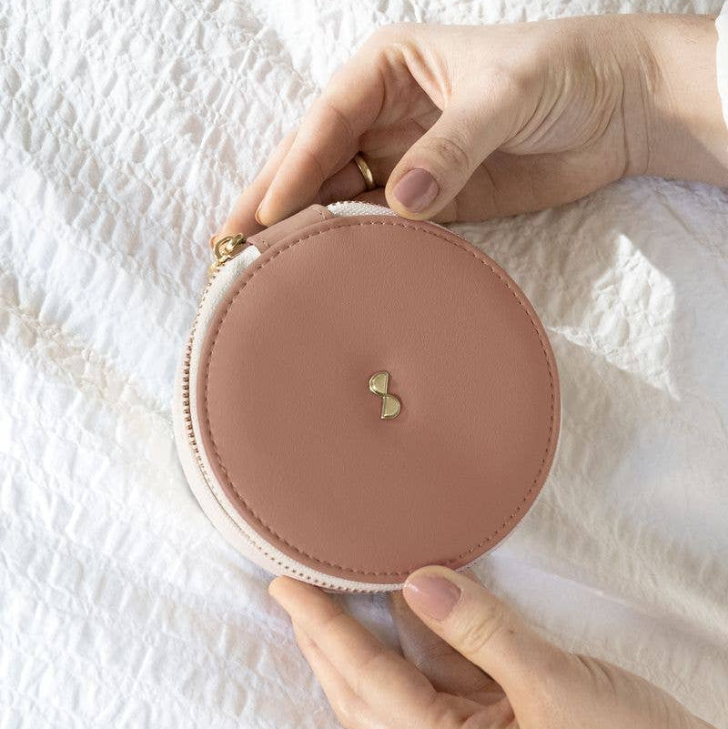 Round Stackers blush and cream travel jewellery box  held by hands on a white textured background