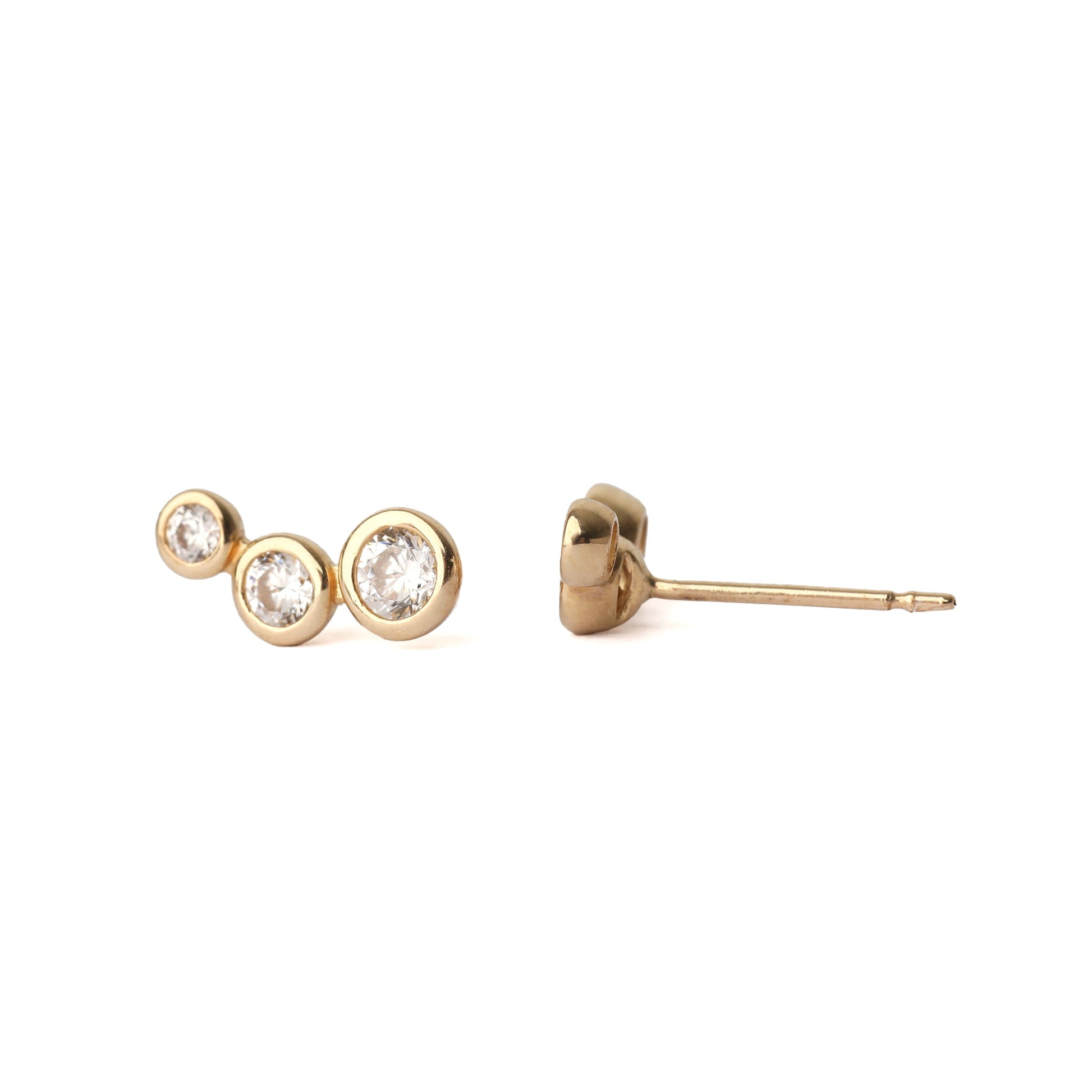A pair of women's solid gold earrings, each with three cubic zirconia gemstones in a bezel setting. The earrings are on a white background, with one earring facing forward and one side on for the shopper to see.