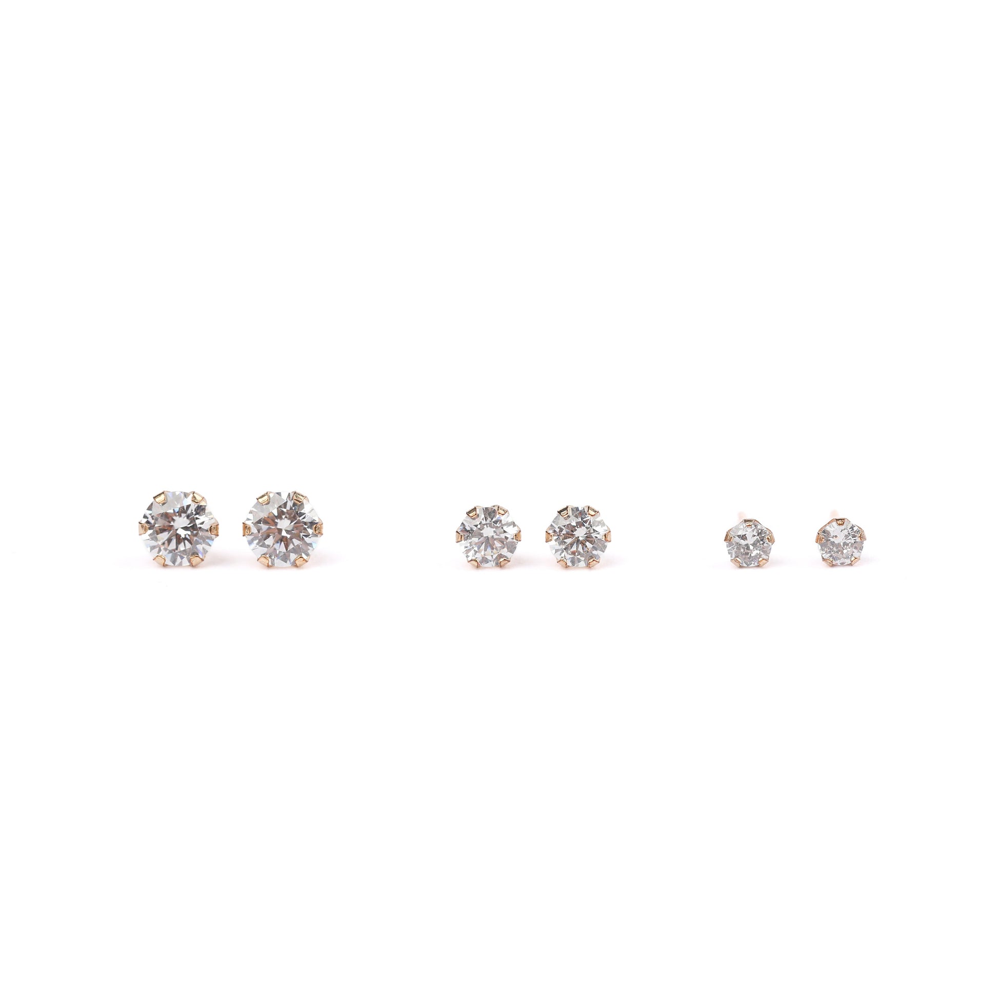 three pairs of solid gold and cubic zirconia earrings on a white background