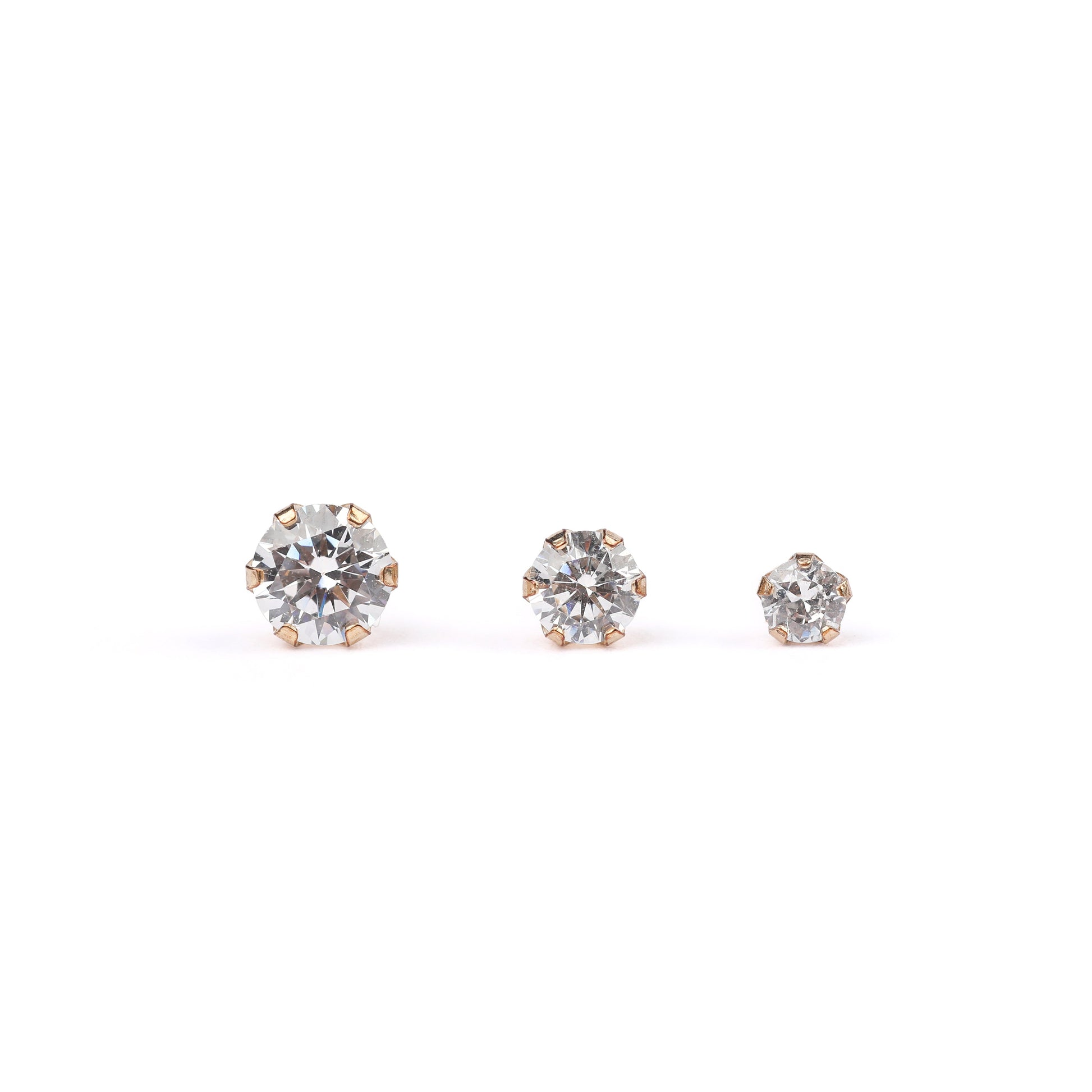 small medium and large solid gold and cubic zirconia stud earrings on a white background