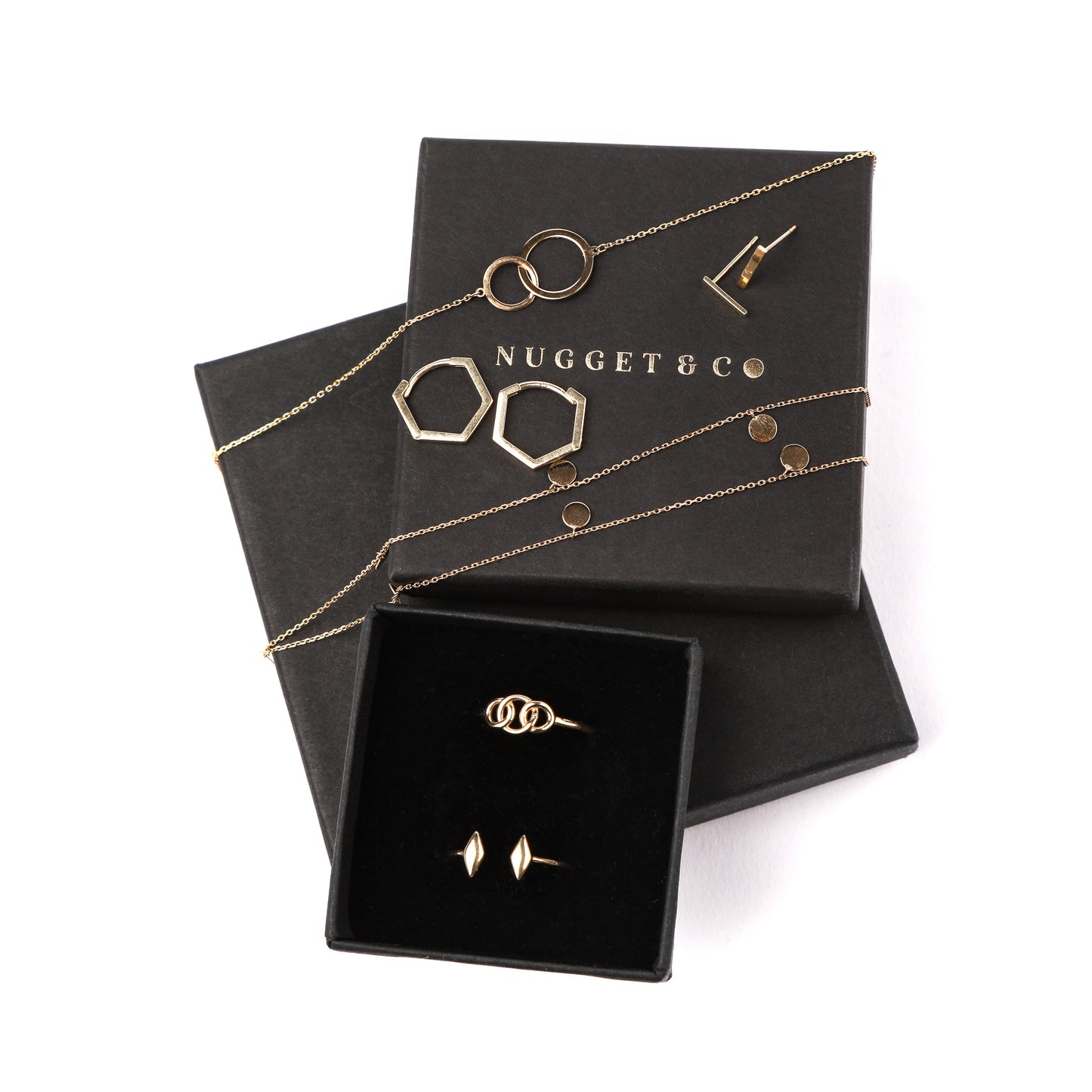 Women's solid gold geometric style jewellery set on a 'Nugget & Co' branded jewellery box on a white background