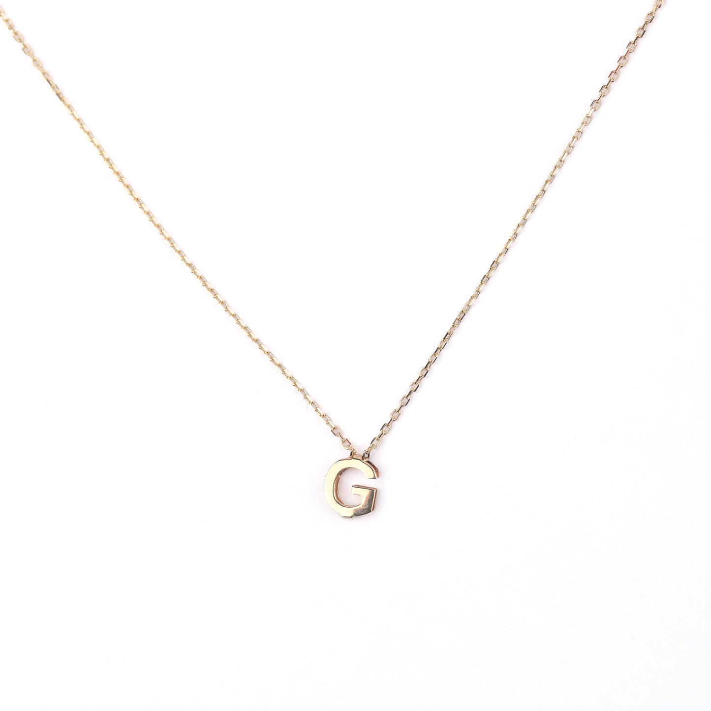 women's solid gold necklace with a 'G' pendant on a white background