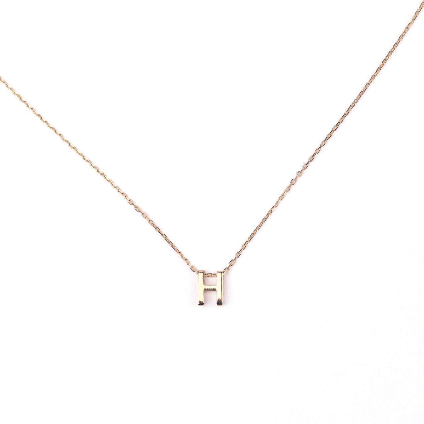 women's solid gold necklace with a 'H' pendant on a white background