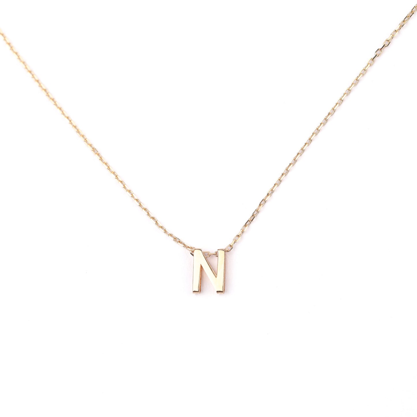 women's solid gold necklace with a 'N' pendant on a white background