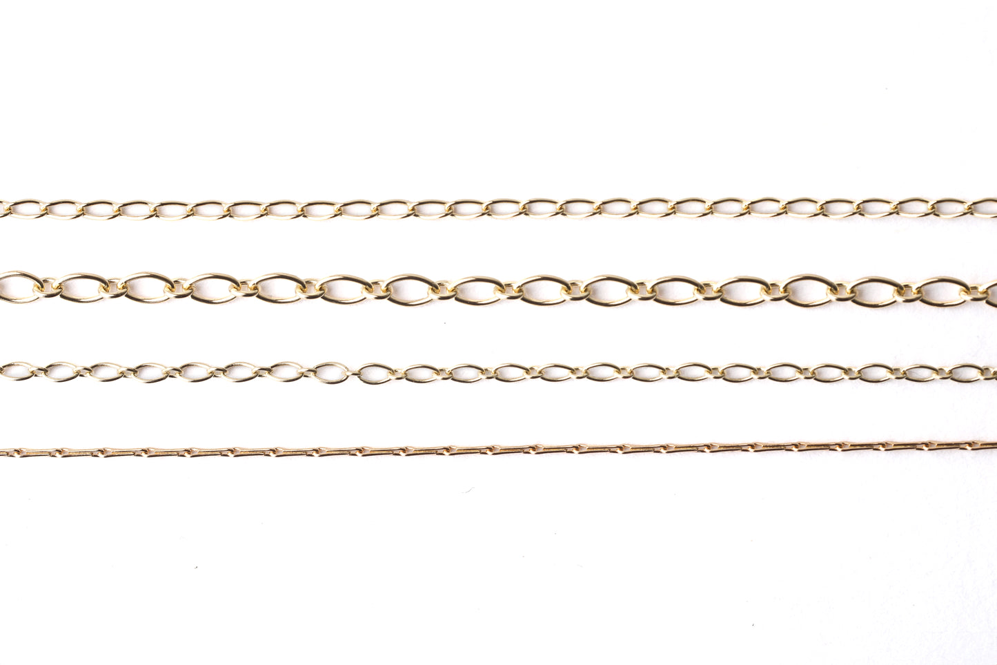 Four different women's solid gold chains, hayseed, trace, oval trace 2mm and oval trace 3.5mm for necklace and bracelets on a white background