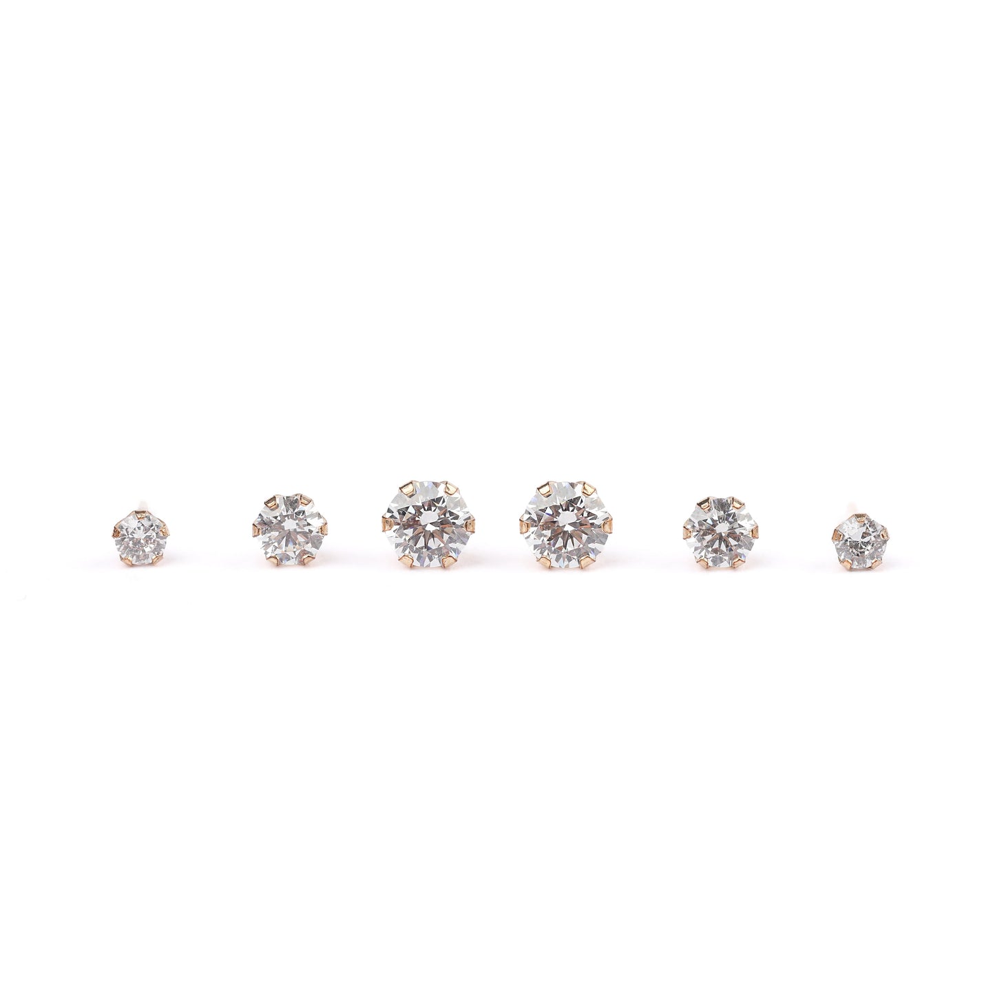 three pairs of solid gold stud earrings with cubic zirconia on a white background