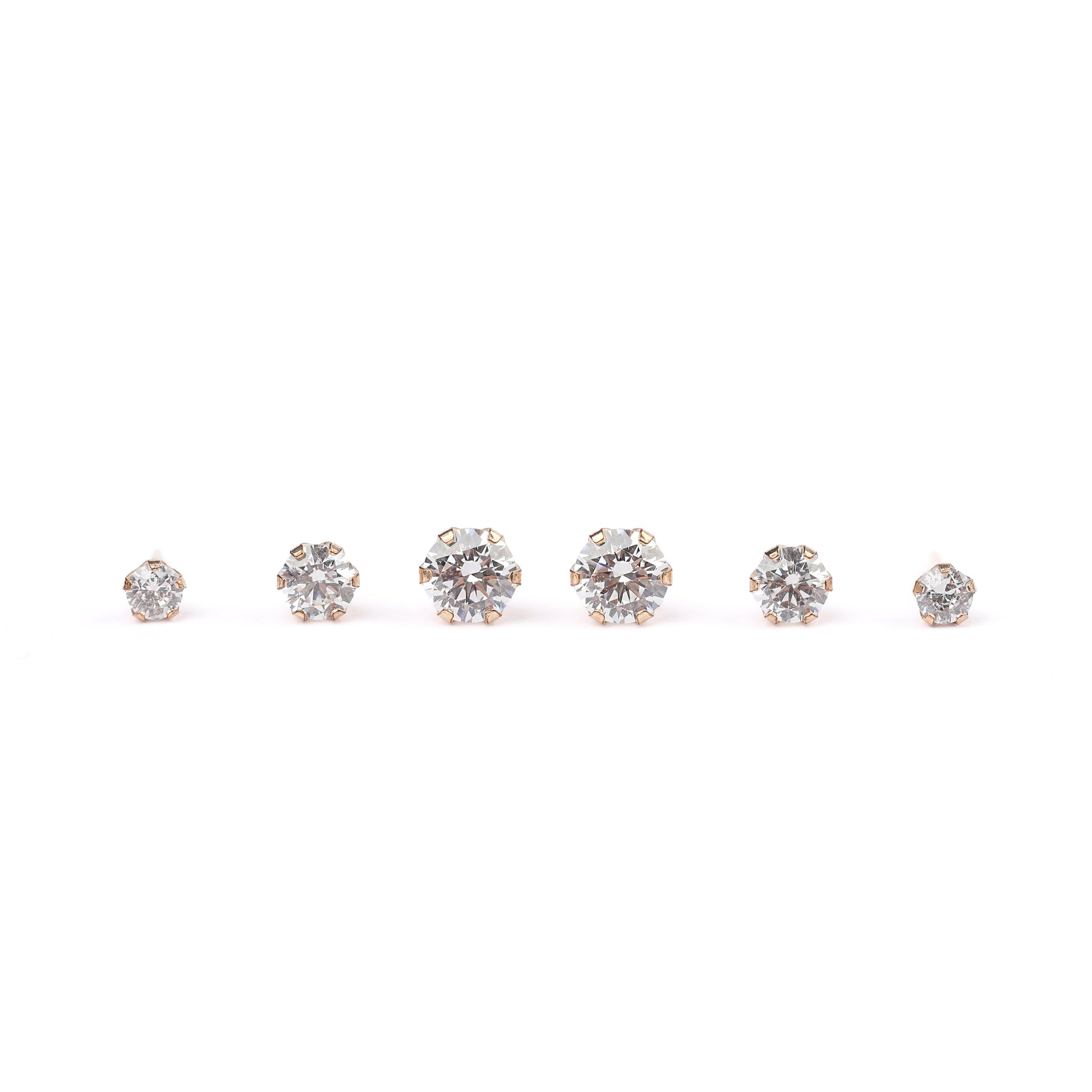 three pairs of solid gold stud earrings with cubic zirconia on a white background